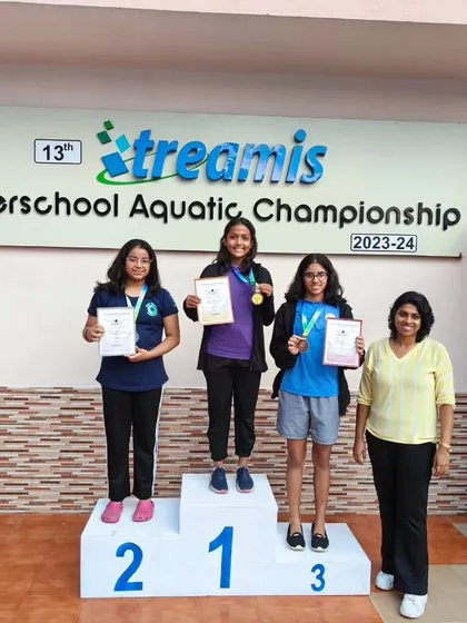 A proud coach and proud swimmers on the podium. These moments are a culmination of months of hard work and dedication from the entire team.