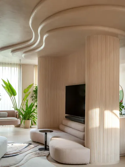 We embraced the challenge of two oddly placed columns by wrapping them in a sweeping, curved wall. This became the room's focal point, integrating a custom sofa and creating a seamless flow that defines the space.