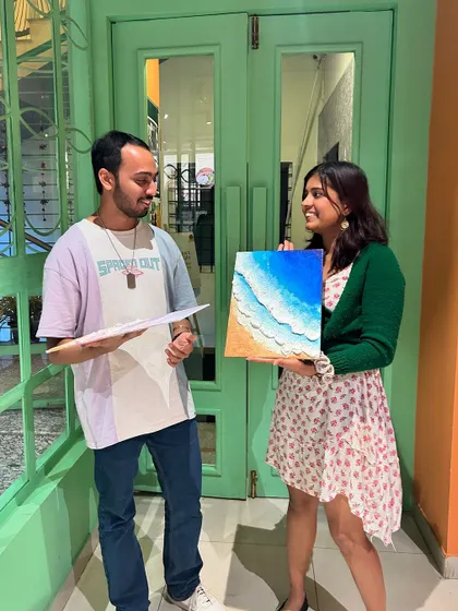 A happy couple with their finished seascape painting. It's a beautiful piece of art and a memory of a fun date.