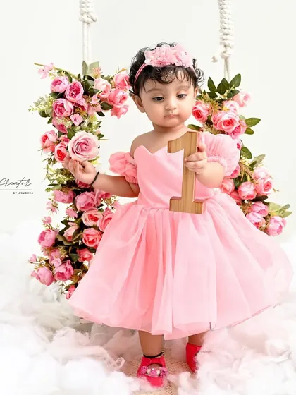 Standing tall and proud with her floral swing. Dressed in a beautiful pink gown, she holds a single rose, looking like a true fairytale princess.