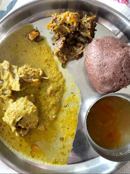 A hearty meal of ragi mudde with a flavorful chicken curry and rasam, an example of how non-vegetarian dishes fit into a balanced plan.
