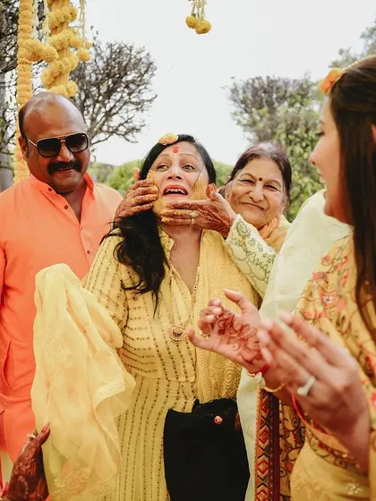 A candid moment of a family member getting playfully smeared with haldi. These celebrations are for everyone to enjoy.