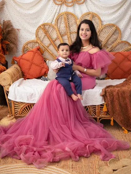 A mother and son portrait in our autumn-themed setup. The mother's dramatic pink gown provides a stunning contrast to the warm, earthy tones of the backdrop.