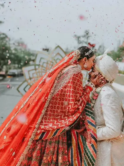A sweet kiss under the floral arch after the ceremony. This candid moment captures the pure bliss and relief of finally being married.