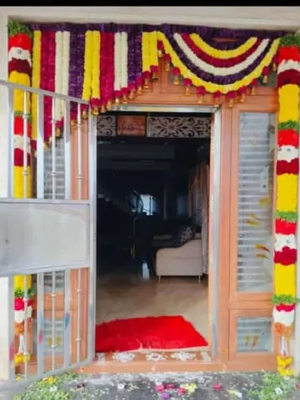 A full and festive main door decoration with colorful flower garlands. This is a popular choice for housewarming ceremonies to welcome good fortune into the new home.