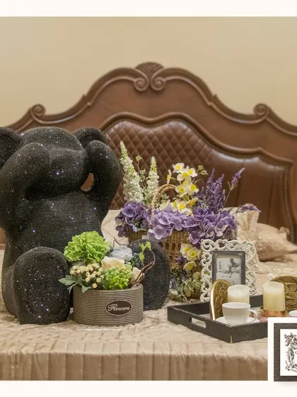 This charming bedroom setting is enhanced by a collection of floral arrangements, a sparkly teddy bear, and other decorative accents, creating a cozy and personalized space.