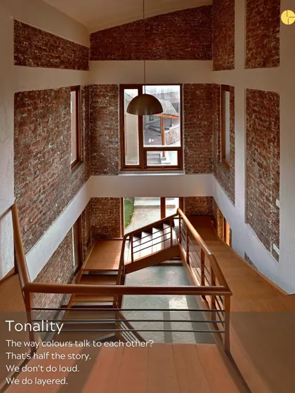 Tonality is half the story. We don't do loud; we do layered. This view in one of our projects shows how the warm tones of brick and wood talk to the cool white walls, creating a balanced and harmonious composition.