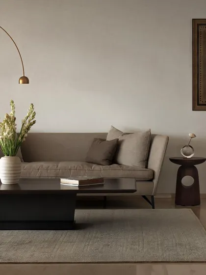 We designed the furniture in this living room to create a soft, elegant, and cohesive space. The low-profile coffee table, sculpted wooden side table, and arched floor lamp work together to establish a calm and inviting atmosphere.
