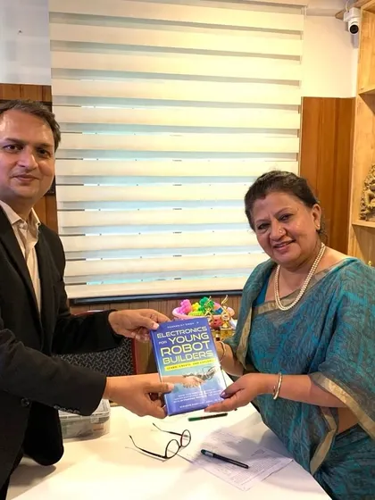 Our founder presents his book, "Electronics for Young Robot Builders," to the managing trustee of Lawrence High School, highlighting our commitment to providing the best learning opportunities.