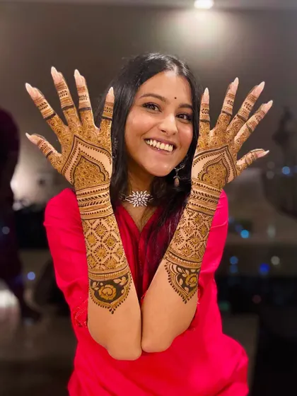 The happy bride, loving her minimal yet stunning bridal mehendi. Her smile says it all.