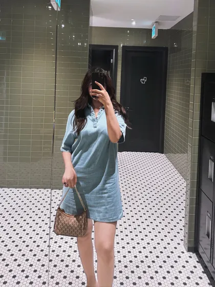 A mirror selfie showing off the Calvin Klein denim dress and Michael Kors bag.