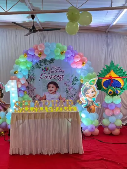 This decoration was for a combined first birthday and naming ceremony with a princess and Radha-Krishna theme. I used a pastel balloon arch, a custom 'Happy Birthday Princess' backdrop, and various character cutouts.