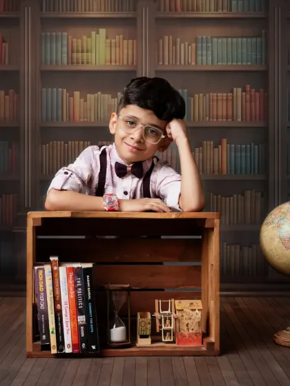 For the little scholar. Our library-themed shoot with books and a globe is perfect for capturing your child's curious nature.