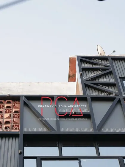 A detail shot of the upper portion of the Chadha Properties facade, highlighting the branding and the geometric metal framework.