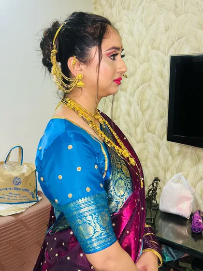 A side profile of the Maharashtrian bride, showing the classic makeup with a red bindi and nose ring (nath).