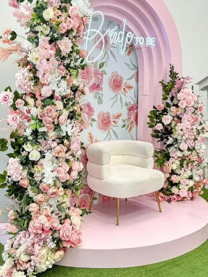 For the bride-to-be, I create vibrant and joyful spaces. This stunning setup features a pastel pink archway overflowing with florals, a custom neon sign, and a plush seat, making it the perfect photo-worthy spot for a bridal shower.