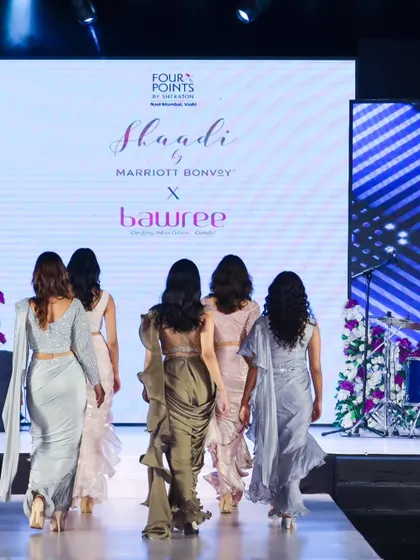 Models walking the finale for a 'Shaadi by Marriott Bonvoy' event, showcasing a collection of modern sarees. This back-facing shot emphasizes the drape and silhouette of the garments.