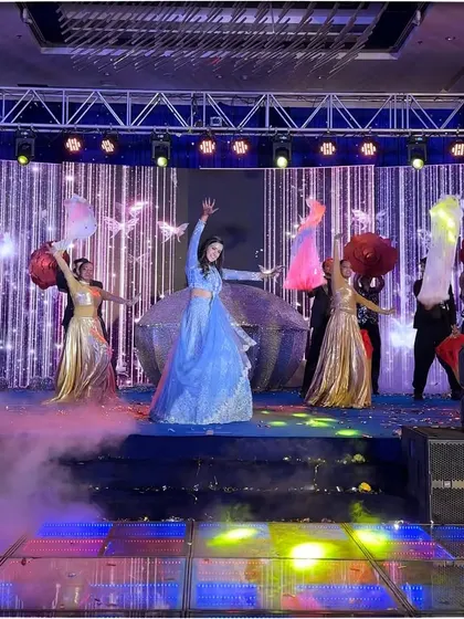 The bride's talent and charm shone brightly in this performance, surrounded by dancers and smoke on a vibrant stage.