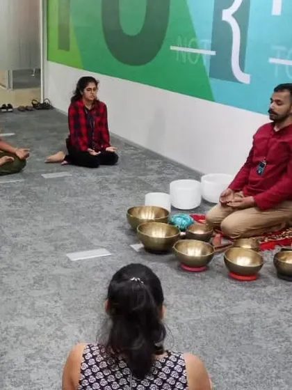 Here you can see a small group of professionals seated in meditation. This phase of the session helps quiet the mind before the deep relaxation of the sound bath, and it can be done right in a company meeting room.
