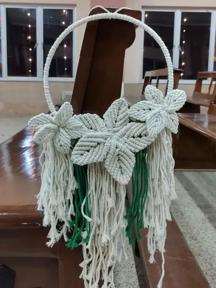 A closer look at the floral wreath hanger, showing the mix of white and green cords.