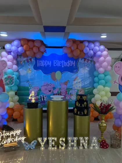 A colorful Peppa Pig party for Yeshna's 4th birthday, with large cutouts of Peppa and George and a rainbow balloon arch.