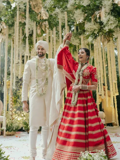 A moment of pure celebration as the couple rejoices after their wedding ceremony. The bride's raised hand and joyful expression say it all.