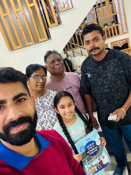 A family, including a young girl holding our informational booklet, poses with our team. We believe in educating and empowering every household.