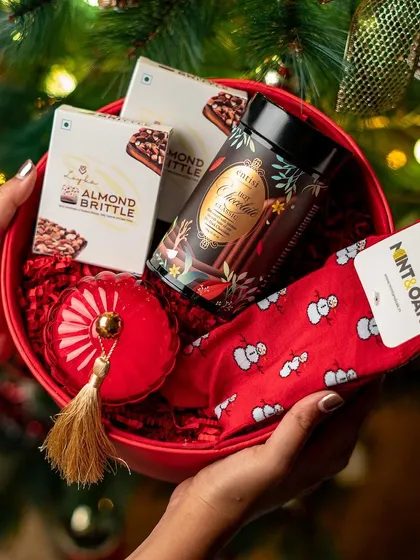 Getting into the festive spirit with this Christmas-themed gift bowl. We curate hampers for all occasions, filled with seasonal treats like hot chocolate, almond brittle, and fun snowman socks.
