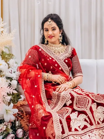 This bride looks stunning in a red lehenga paired with a gold-plated Kundan set. This is a classic and timeless choice for a North Indian style wedding or reception.