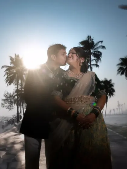 A romantic kiss silhouetted against the morning sun and misty palm trees. This dreamy, atmospheric shot is perfect for an early morning beach session.