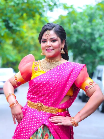 This client is ready for her photoshoot in a vibrant half-saree. The makeup is bold and defined, perfect for the camera, creating a look that's both traditional and trendy.