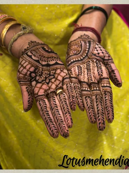 This guest mehendi features a beautiful floral pattern in the center, surrounded by traditional grid and leaf motifs.