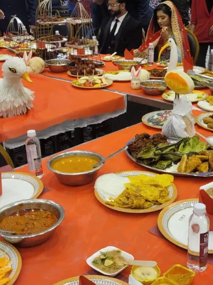 The head of the table at a wedding, showcasing the abundance of food, from kebabs on birdcage stands to various curries, salads, and our artistic fruit sculptures.