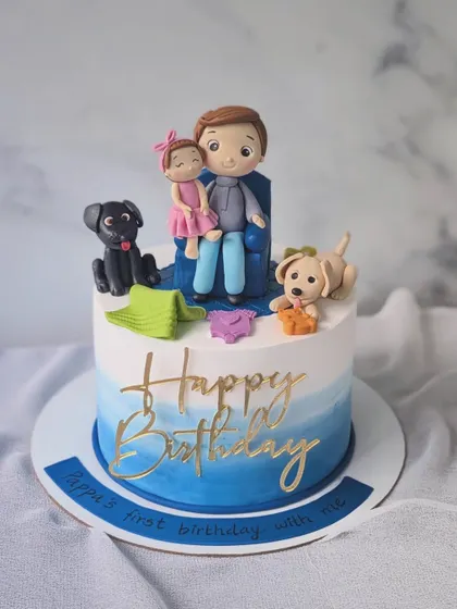 A special cake for a new father's first birthday with his daughter. The design features a custom figurine of them together with their two dogs.