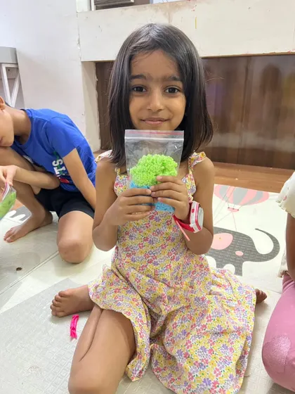 This proud camper shows off the colorful, textured material she created in a sensory science activity. It's a great way to explore polymers and material properties.