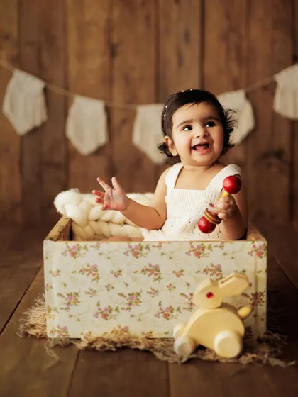 A burst of pure joy! This little girl's happy laugh during her sitter session in a floral box is absolutely contagious.