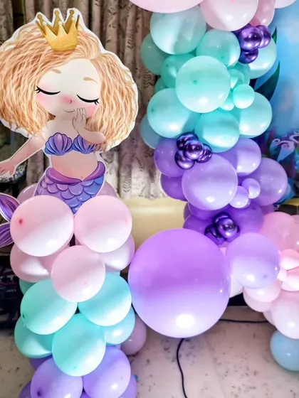 A cute mermaid princess cutout on a pillar of balloon's greets guests as they arrive.
