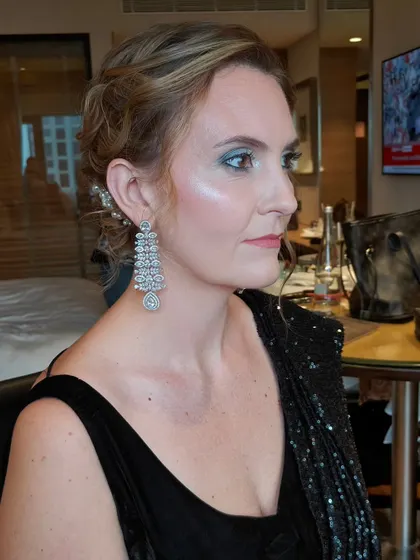 Another angle of this glamorous look. The highlighter on her cheekbones catches the light beautifully, adding to the overall glam effect.