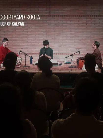 A live shot from the "Colors of Kalyan" concert. The focused lighting on the artists and the dark, attentive audience highlight the immersive quality of our classical music events.