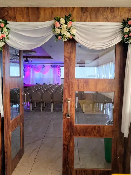 A simple and elegant floral drape over a doorway for a formal event.