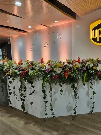 I transform standard office areas into vibrant, welcoming spaces. This lush floral arrangement on the UPS reception desk adds a touch of nature and sophistication for your launch event.
