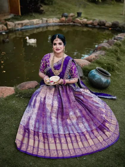 A serene portrait of a woman in a beautiful purple half-saree, taken by a pond. This was part of a special shoot for the Sankranti festival.