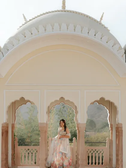 The bride stands framed by the arches of the Jaibagh Palace during her Mehendi. This portrait captures her elegance against the grandeur of the royal venue.