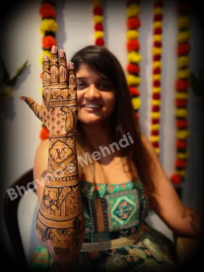 A happy client showing off her full back hand bridal mehndi. The design is rich with elephant motifs and personalized initials.