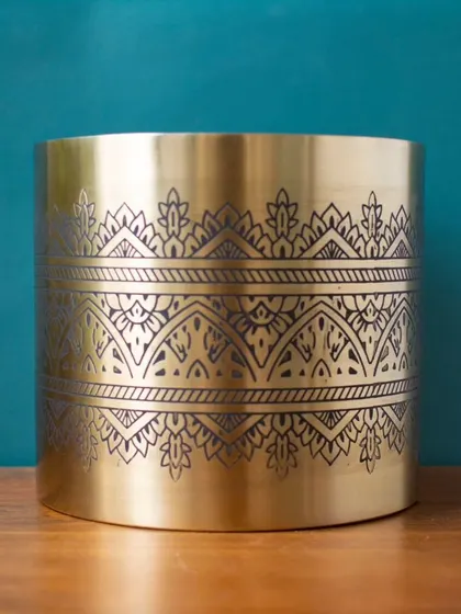 This front view of the Nikhat gold planter showcases the full expanse of its beautiful, traditional etched pattern, making it a stunning decorative piece.