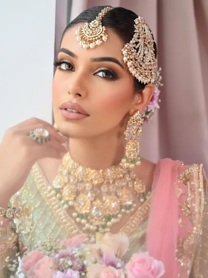 A close-up of the pastel glam look, featuring glowing skin, a soft pink flush, and a beautiful Passa (side tikka).