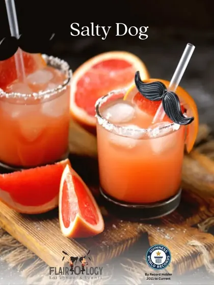 The 'Salty Dog' cocktail, garnished with a fun mustache straw. It's a refreshing mix of gin or vodka with grapefruit juice and a salted rim.