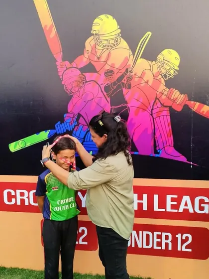 A parent supporting a young player at the presentation ceremony. The support system of family is crucial for any young athlete.