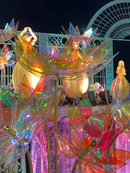 The iridescent lotus flowers catch the light beautifully, creating a rainbow of colors that adds to the magical atmosphere of the stage.