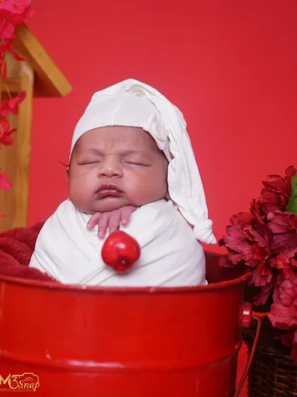 A close-up of the baby's sweet face in the sleepy hat. The focus is on their peaceful expression and tiny features.
